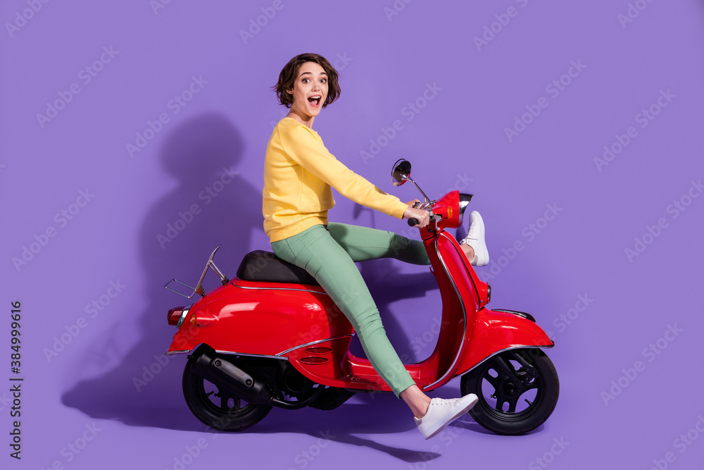 Poster full length body size side profile photo of female millennial with bob hair driving red scooter smil