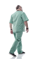 in full growth. Mature doctor with a stethoscope confidently stepping forward