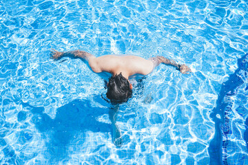 Young man enyoing the day at the swimming pool