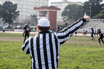 American football referee signaling during a game.