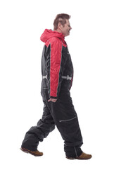 Fototapeta premium man in a winter insulated jumpsuit reading walking forward