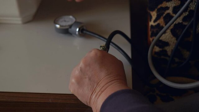 Close-up of an elderly woman measuring her blood pressure
