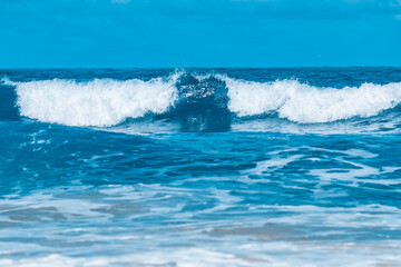 Water wave splash on blue sea background.