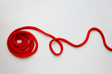 Red textured cord roll with curved line isolated on white background