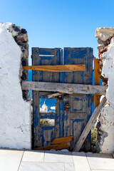 Very old door at Oia, Santorini island, Cyclaeds, Geece.  sea is visible across the destroyed door