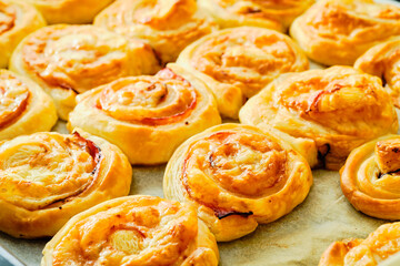 Fresh puff pastry rolls on baking tray