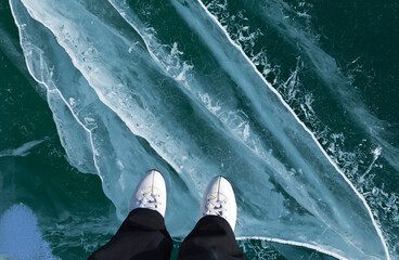 Frozen Lake Baikal. Top view of the surface of beautiful transparent blue ice with stripes of...