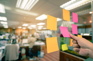 Colorful post it paste on glassed have copy space for put text to do list and hand of people need...