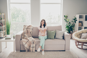 Photo portrait of woman sitting on couch with crossed legs smiling indoors
