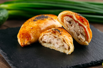 Cut oriental baked pie with chicken meat samsa
