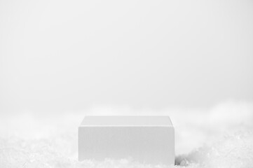 Podium geometric shape white on a white background. Winter scene, showcase with snow for product presentation. Minimalistic light pedestal for cosmetic. Copy space