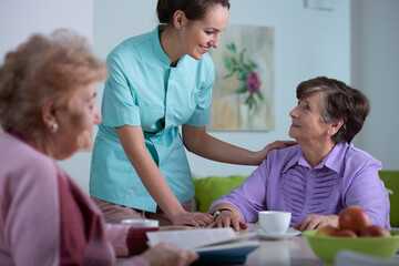Obraz premium Senior patient of professional nursing home and helpful young nurse