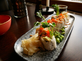Sushi lunch, california roll with salmon, rice, white roe, seawseed, chili mayonnaise and edamame beans