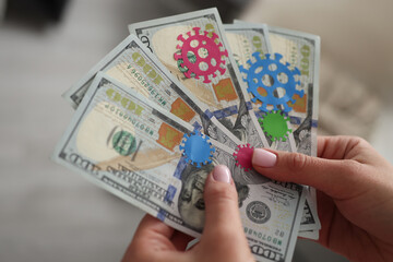 Female hands hold in hand dollar bills infected with coronavirus infection close-up. Cash as reason...