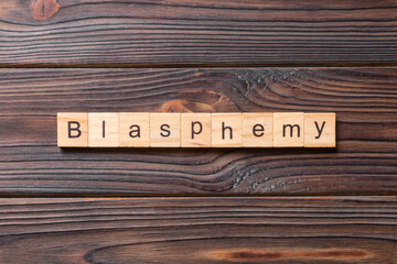 BLASPHEMY word written on wood block. BLASPHEMY text on cement table for your desing, concept