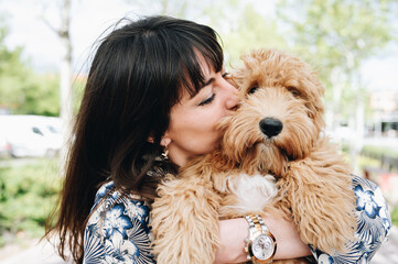 Attractive woman kisses and hugs her lovely puppy. Love for animal concept.