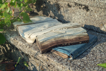 Spoiled old  shabby books on the stair step illuminated with sunlight