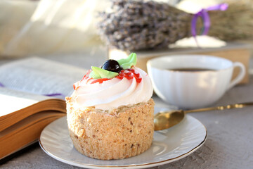 Sponge cake close-up. In the background, a blurred mug of tea and a bouquet of dry lavender. Concept - traditional English afternoon tea.  Selective focus.