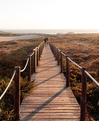 Fototapeta premium Casal em ponte de madeira na praia do Guincho
