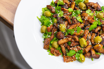 Fresh salad with roast pork, olives and cilantro