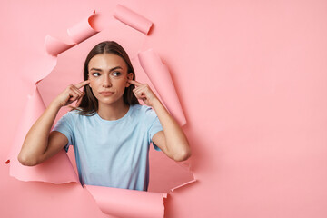 Young caucasian brunette woman plugging her ears with fingers