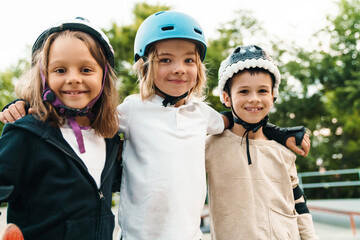 Happy cheerful kids with skateboards at the ramp