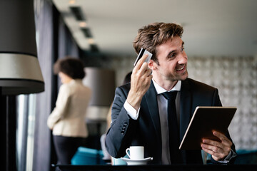 Portrait of cheerful businessman paying for order with credit card in cafe