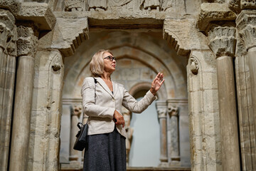 Fototapeta na wymiar Woman exploring medieval expositions in museum