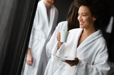 Portrait of a beautiful young healthy black woman relaxing in a robe and drinking coffee