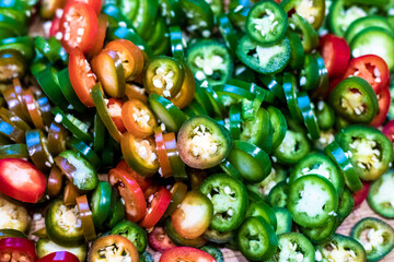 Fototapeta na wymiar Pile of colourful ripe jalapenos cuts ready for cooking and preservation.