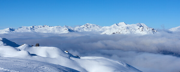 Fototapeta na wymiar Mountain winter panorama with clouds in the valley near Tignes high-altitude ski resort in France during the winter season.