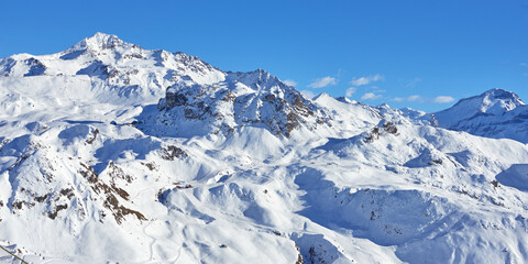 Panoramic view of the mountain range with ski pistes and lifts near Tignes high-altitude resort in France during the winter season.