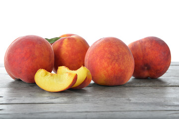 Sweet ripe peaches on table against white background