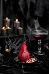 Red wine poached bloody gothic Halloween pears with cream, wine & candles