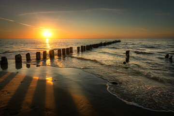 Baltic Sea seascape at sunset. Wooden breakwater