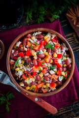 salad with red beans, corn and bell peppers in a wooden salad bowl, selective focus