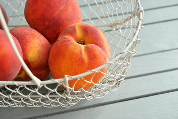 Sweet peaches in basket on table, closeup