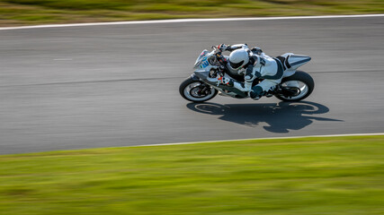 A panning shot of a racing bike cornering on a track.