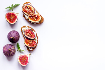 Sandwiches with figs, cheese and honey on table