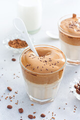 Cold Dalgon coffee in a glass on a white background. A trendy drink made from whipped instant coffee and milk. Close up.