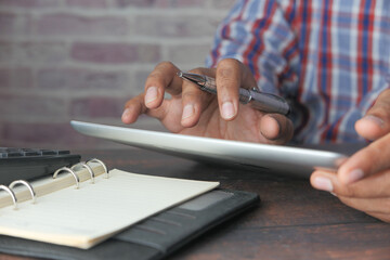 man's hand working on digital tablet 
