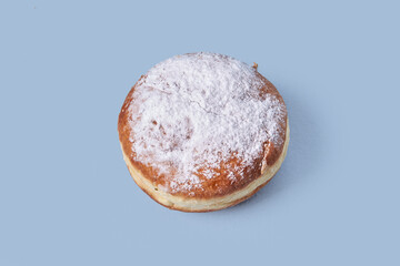 Top view of sweet pastries with filling, sprinkled with powdered sugar. Isolated on a blue background. High-calorie food.