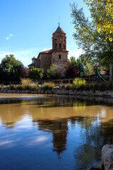 Fototapeta na wymiar Exterior facade of the Church of San Sebastian S XVIII next to a pond