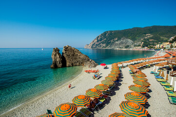 Beach umbrellas lining the beach in Monterosso al Mare, Cinque Terre, Liguria, Italy