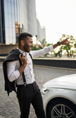 Bearded Indian Muslim businessman talking to taxi Driver in city