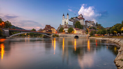 Fototapeta na wymiar Aarburg, Switzerland. Panoramic cityscape image of beautiful city of Aarburg with the reflection of the city in the Aare river at sunset.
