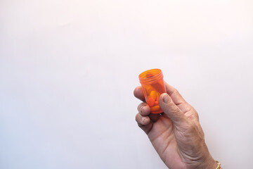 top view of senior women holding pill container on white background 