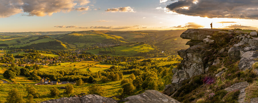View of lone piper at at sunset on Curbar Edge, Curbar, Hope Valley, Peak District National Park, Derbyshire, England, United Kingdom