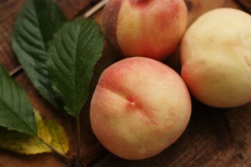 Fresh juicy peaches with leaves on the table
