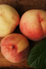 Fresh juicy peaches with leaves on the table